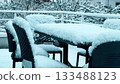 Snow covered outdoor terrace furniture near Grenoble after early winter snowfall, France 133488123