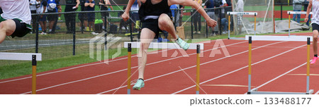 High School Athlete Competes in Hurdle Race During Track Event High School Athlete Competes in Hurdle Race During Track Event 133488177
