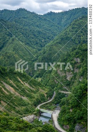 Deep green and winding mountain roads around Lake Okutadami in Niigata Prefecture in summer 133488192