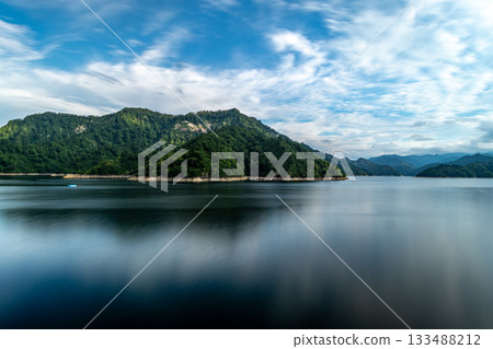 新潟縣奧田尻湖的長曝光照片，展現瞭如鏡般的湖面和雄偉的夏季山巒。 133488212