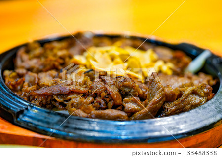 Bulgogi served in a hot plate and sprinkled with dry garlic. Korean food. Bulgogi served in a hot plate and sprinkled with dry garlic. Korean food. 133488338