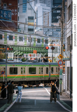 A train passing through a railroad crossing in Tokyo 133489087