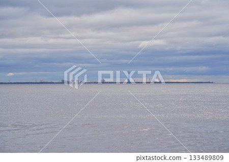 Distant view of modern city skyline across the Gulf of Finland under cloudy sky. Distant view of modern city skyline across the Gulf of Finland under cloudy sky. 133489809