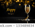 A glass of champagne with golden ribbon in new year party and text Happy New Year on fireworks in night sky background. 133489834