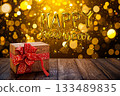 A New Year card with the gold text Happy New Year, a gift box on wooden table and golden bokey background. 133489835