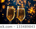 Closeup of champagne glasses in New Year party on glowing fireworks background. 133489843