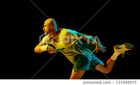 Energetic tennis player hitting forehand illuminated by cinematic lighting 133489975