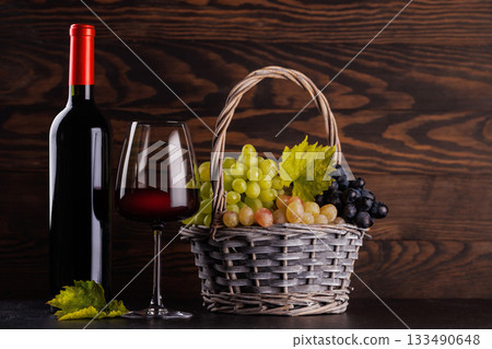Red wine bottle with a glass and basket of fresh grapes Red wine bottle with a glass and basket of fresh grapes 133490648