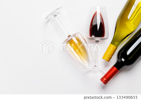 Wine glasses with red and white wine and bottles lying on white background 133490655
