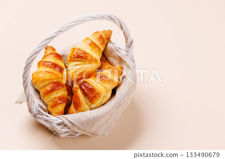 Freshly baked croissants in wicker basket on light background Freshly baked croissants in wicker basket on light background 133490679