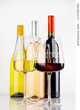 Different wine bottles and glasses on white background 133490706