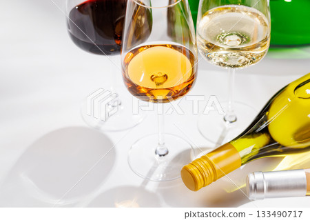 Different wine bottles and glasses on white background 133490717