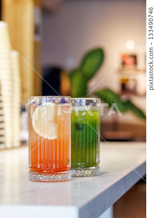 Assorted summer lemonades in glass jars with fresh fruits, ice, and garnishes 133490746