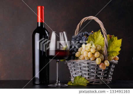 Red wine bottle with a glass and basket of fresh grapes Red wine bottle with a glass and basket of fresh grapes 133491163