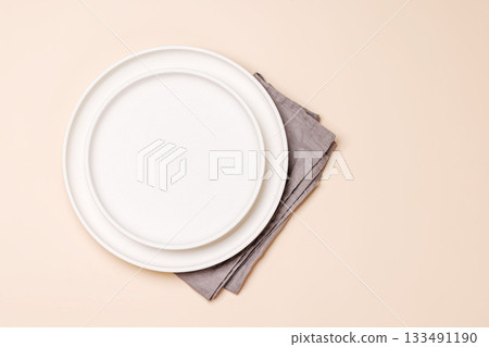 Empty plate on beige background, food mockup with natural light Empty plate on beige background, food mockup with natural light 133491190