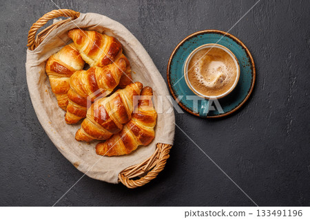 Aromatic croissants in wicker basket with cup of coffee Aromatic croissants in wicker basket with cup of coffee 133491196