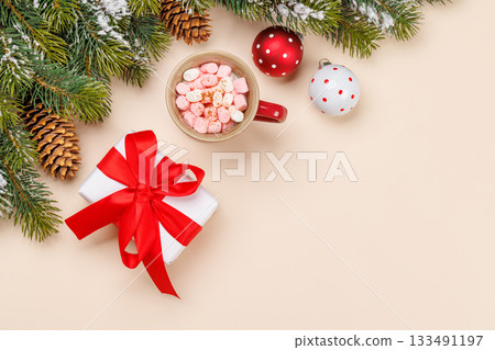 Gift box, cup with marshmallows, snowy fir branches 133491197
