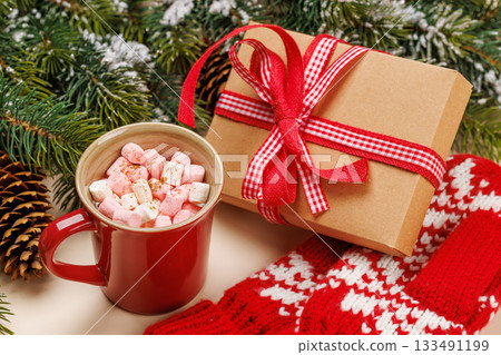 Gift box, cup with marshmallows, snowy fir branches 133491199