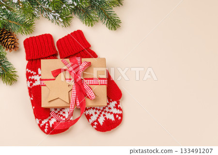 Gift box on winter mittens and beige background Gift box on winter mittens and beige background 133491207