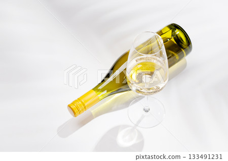White wine bottle and glass on white background White wine bottle and glass on white background 133491231