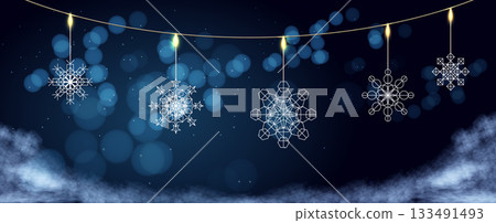 Decorative snowflakes hanging on a string against a dark background during winter festive season 133491493