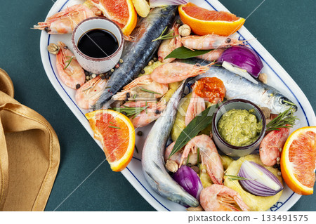 Plate with raw marinated seafood. 133491575