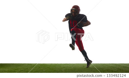 American football player jumping forward with intense determined emotion on field isolated on white background 133492124