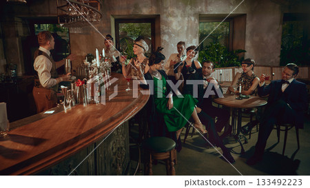 Vintage bar gathering with cheerful friends enjoying cocktails in glamorous retro style Vintage bar gathering with cheerful friends enjoying cocktails in glamorous retro style 133492223