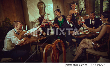 Group of stylish friends making a festive retro toast in warm vintage setting Group of stylish friends making a festive retro toast in warm vintage setting 133492230