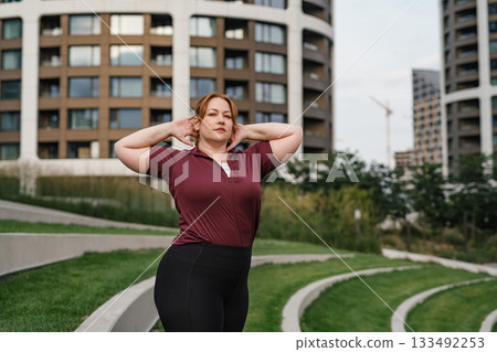 Body positive woman warming up before training. 133492253