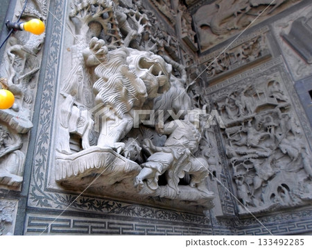 An Intricate Stone Carving of a Lion in Battle Amidst Detailed Relief Sculptures An Intricate Stone Carving of a Lion in Battle Amidst Detailed Relief Sculptures 133492285