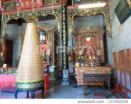 A Temple Interior Featuring a Large Incense Burner, Statues, and Ornate Red and Gold Decor 133492289
