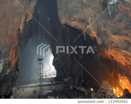 Illuminated Cave Interior with a Temple at the Base and Towering Rock Walls Illuminated Cave Interior with a Temple at the Base and Towering Rock Walls 133492682
