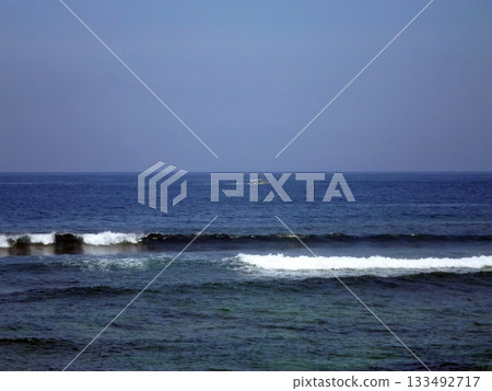 A Small Boat Sails Amidst Rolling Waves on a Vast Blue Ocean Horizon A Small Boat Sails Amidst Rolling Waves on a Vast Blue Ocean Horizon 133492717