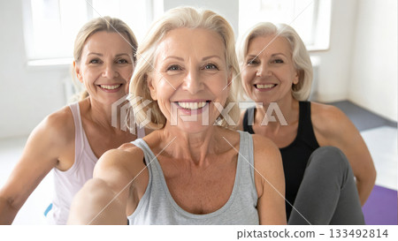 Smiling multi-generational women in activewear take a group selfie 133492814