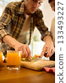 Fresh orange juice in glass on wooden table with warm father and son cooking mood 133493227