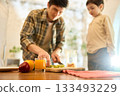 Glass of orange juice with bright kitchen daylight and warm caring family vibe 133493229
