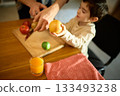 Bright orange juice in glass beside fruits during warm joyful father and son moment 133493238