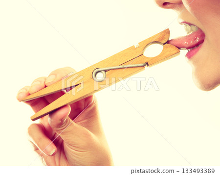 Blonde woman having tongue in clothespin 133493389