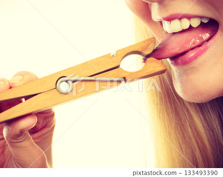 Blonde woman having tongue in clothespin 133493390