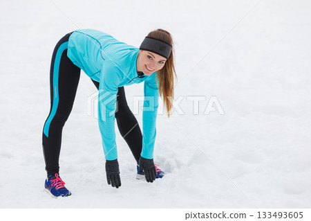 Winter workout. Girl wearing sportswear, stretching exercises. Winter workout. Girl wearing sportswear, stretching exercises. 133493605