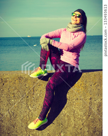 Woman resting after doing sports outdoors on cold day 133493613