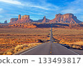 Long highway into Monument Valley at sunset 133493817