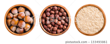 Hazelnuts, with and without shells, and ground, in wooden bowls. Dried hazelnuts, seeds of the hazel tree Corylus avellana in the left bowl, shelled nuts in the center, and ground in the right bowl. Hazelnuts, with and without shells, and ground, in wooden bowls. Dried hazelnuts, seeds of the hazel tree Corylus avellana in the left bowl, shelled nuts in the center, and ground in the right bowl. 133493861