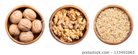 Walnuts, with and without shells, and ground, in wooden bowls. Dried walnuts, seeds of walnut tree Juglans regia, with shells in the left bowl, walnut halves in the center, ground in the right bowl. Walnuts, with and without shells, and ground, in wooden bowls. Dried walnuts, seeds of walnut tree Juglans regia, with shells in the left bowl, walnut halves in the center, ground in the right bowl. 133493865