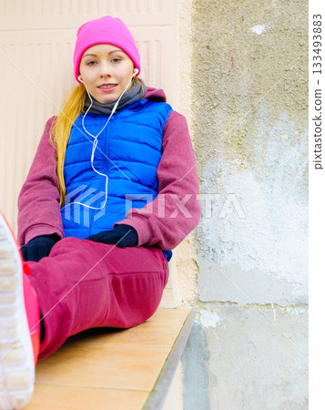 Woman wearing warm sportswear relaxing after exercising Woman wearing warm sportswear relaxing after exercising 133493883