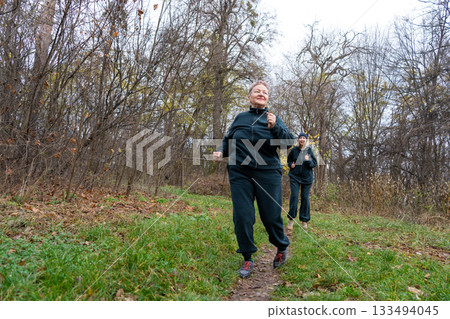 Old Senior Women Jogging on Trail in Autumn 133494045