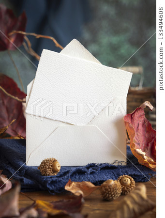 Card on wood near autumn dried leaves closeup, wedding and party mockup in blue, red and orange Card on wood near autumn dried leaves closeup, wedding and party mockup in blue, red and orange 133494608