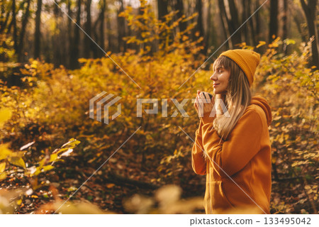 Woman Enjoying Warm Beverage in Autumn Forest Woman Enjoying Warm Beverage in Autumn Forest 133495042