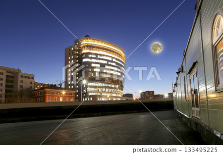 modern office building with big windows at night with the super moon, in windows light shines. Moscow, Russia modern office building with big windows at night with the super moon, in windows light shines. Moscow, Russia 133495225